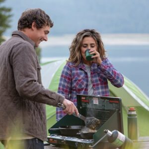 A couple cooking on a coleman 2-Burner Camp Stove